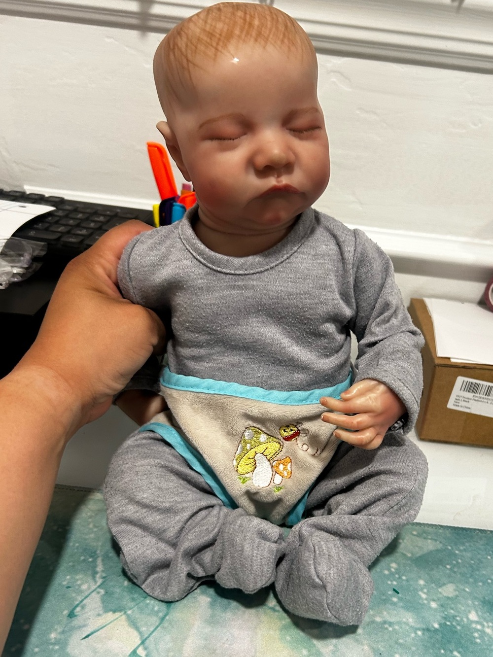 Realistic Baby Doll in Gray Outfit with Blue Trim